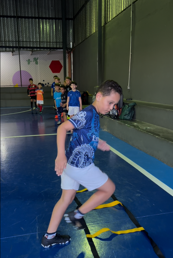 Alunos jogando futsal na quadra do colégio